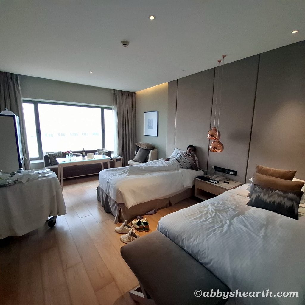 My brother on a bed in the sea-facing Deluxe Twin room at Taj Lands end.