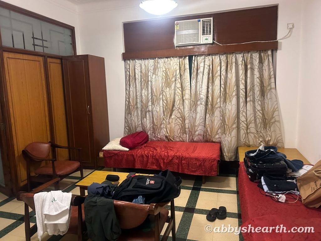 Living room with single bed, air conditioner, and wardrobe in Mumbai.