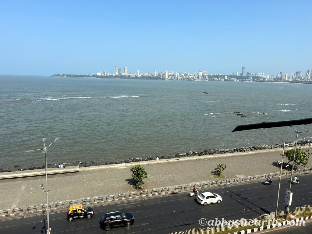 View of Mumbai skyline from Marine Drive with sea and cityscape in background.