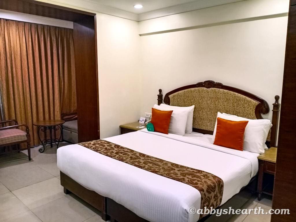 Cozy hotel room with a large bed, decorative pillows, and warm lighting.