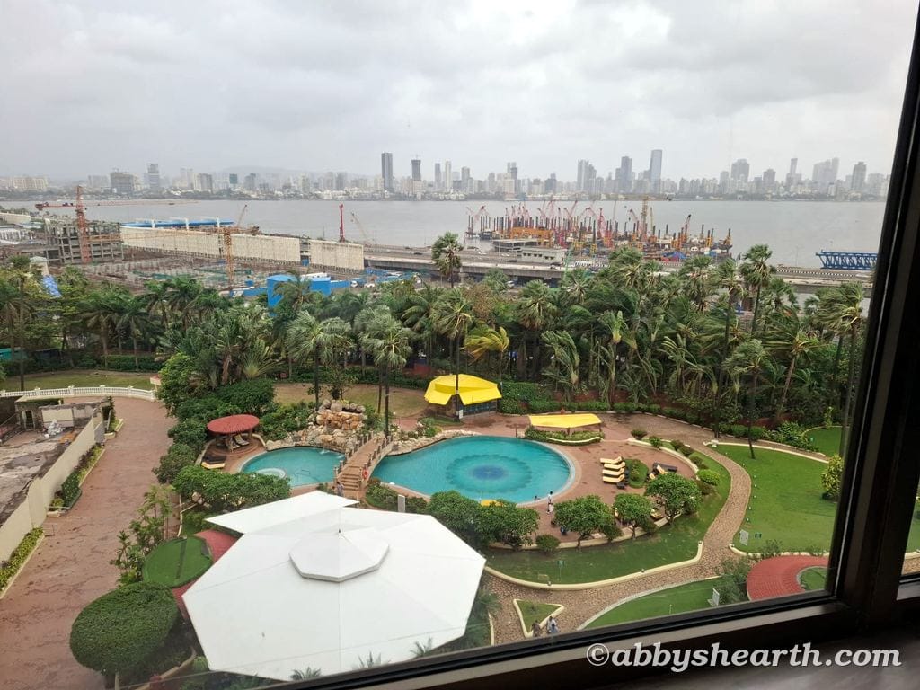 Scenic view of Mumbai skyline with pool and garden at Taj Lands End Hotel.