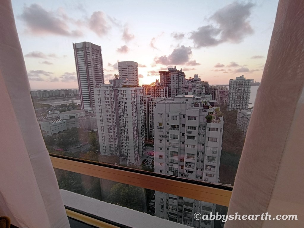 City skyline of Mumbai at sunset with high-rise buildings and clouds.