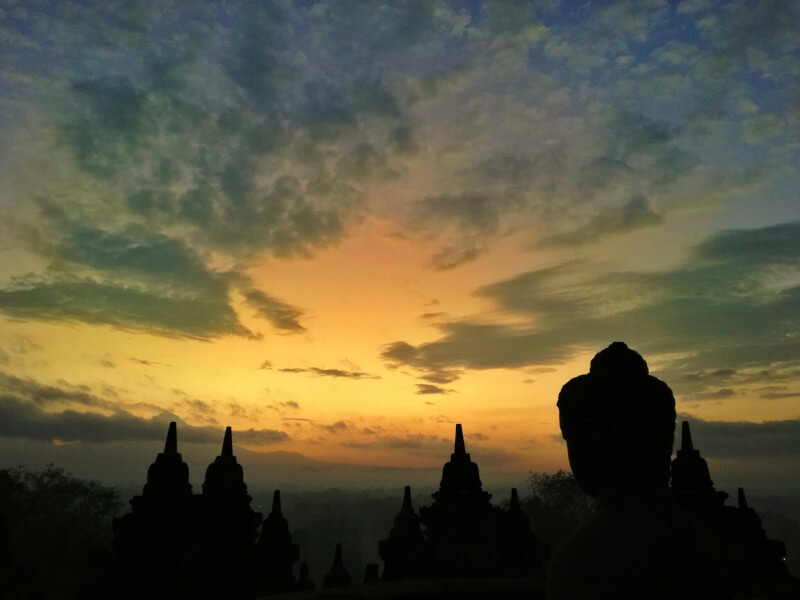 Sunrise at the Borobudur Temple in Indonesia crosses Buddha's face -Pic by Darlene of Point and Shoot Wanderlust