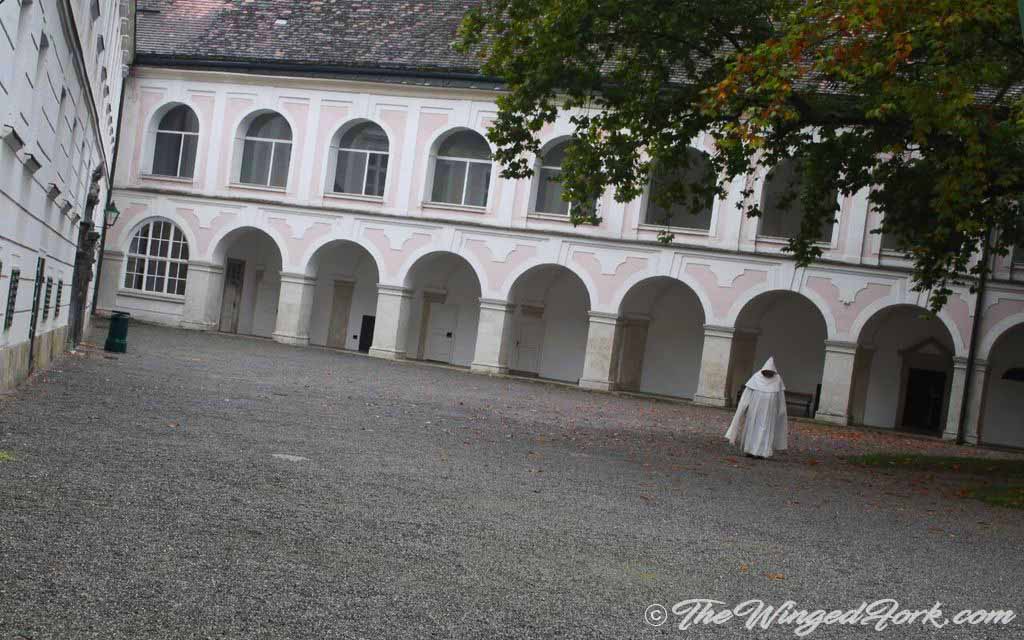 Priest in courtyard of Stift Heiligenkreuz Abbey.