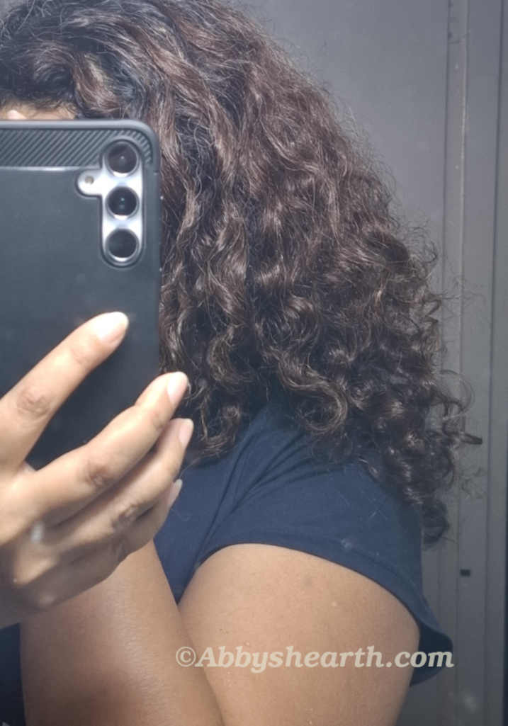 Me with my curly hair in front of a mirror.