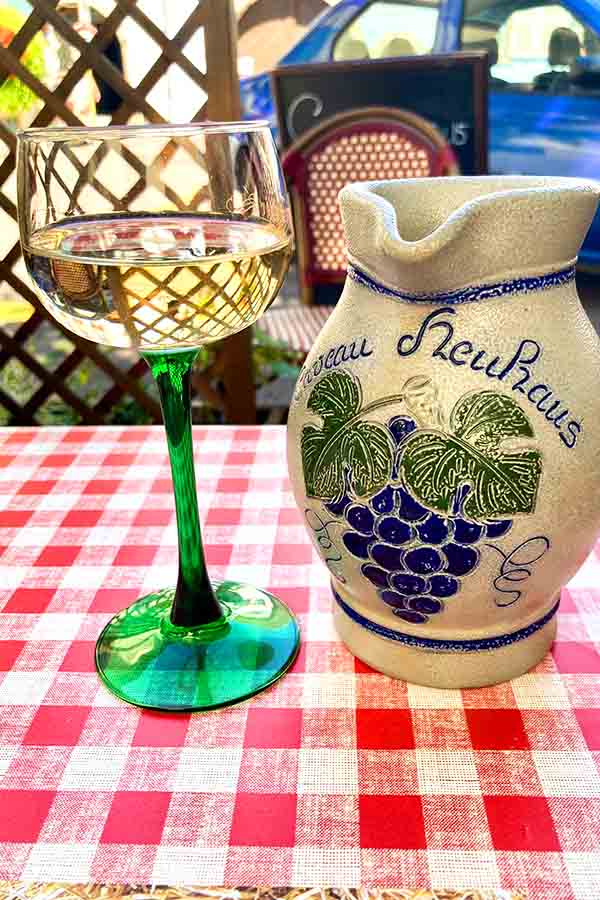 Alsace wine glasses and jug placed on a table.