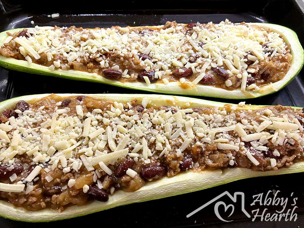 Zucchini boats filled with mince and topped with shredded cheese.
