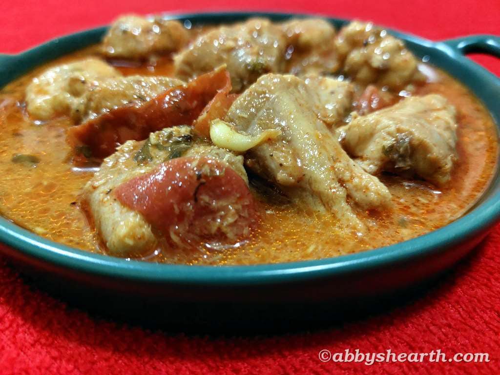 Front view of East Indian mushi lonvas curry aka Milk shark curry in a green dish.