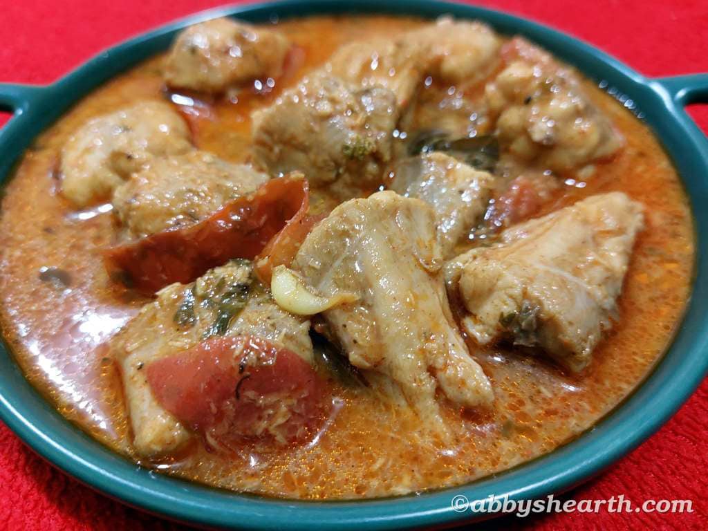Front top view of milk shark curry in a green dish.