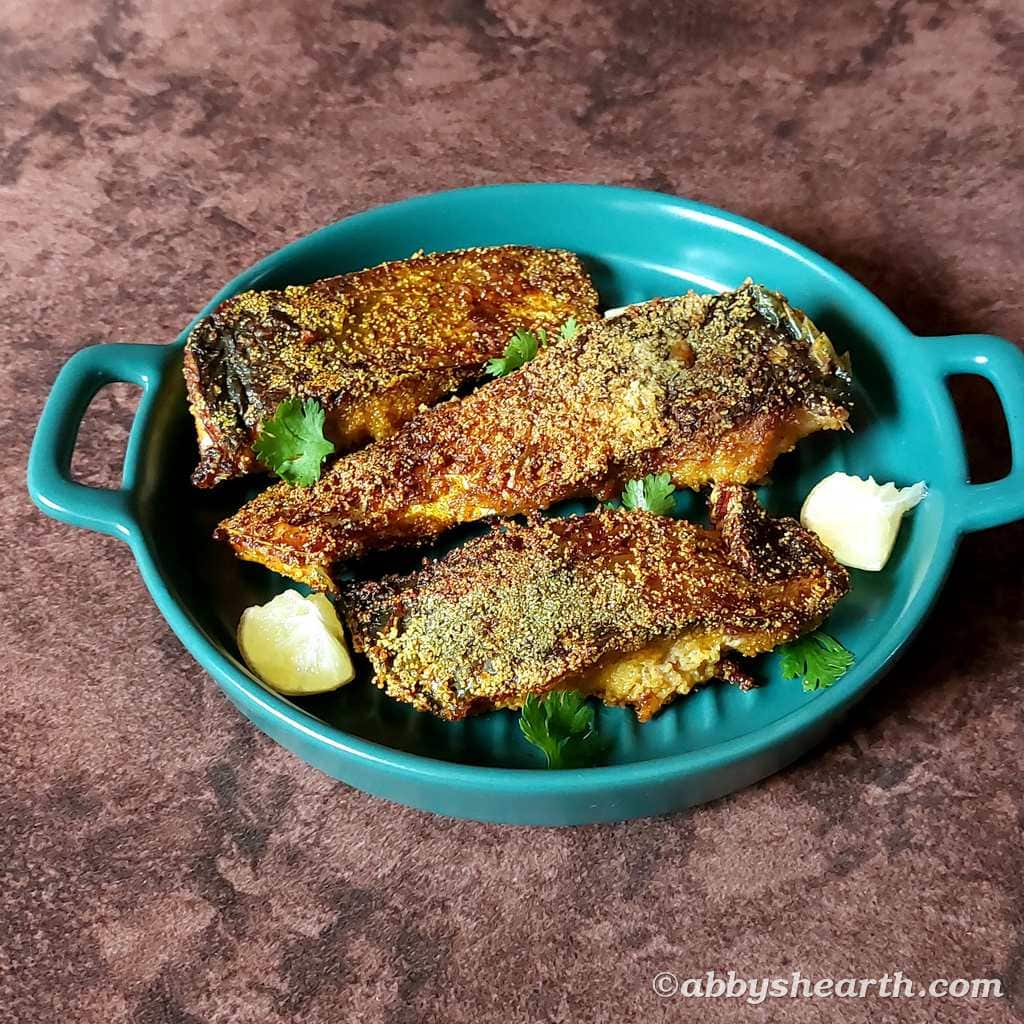Fried palla with lime and parsley in a green serving dish.