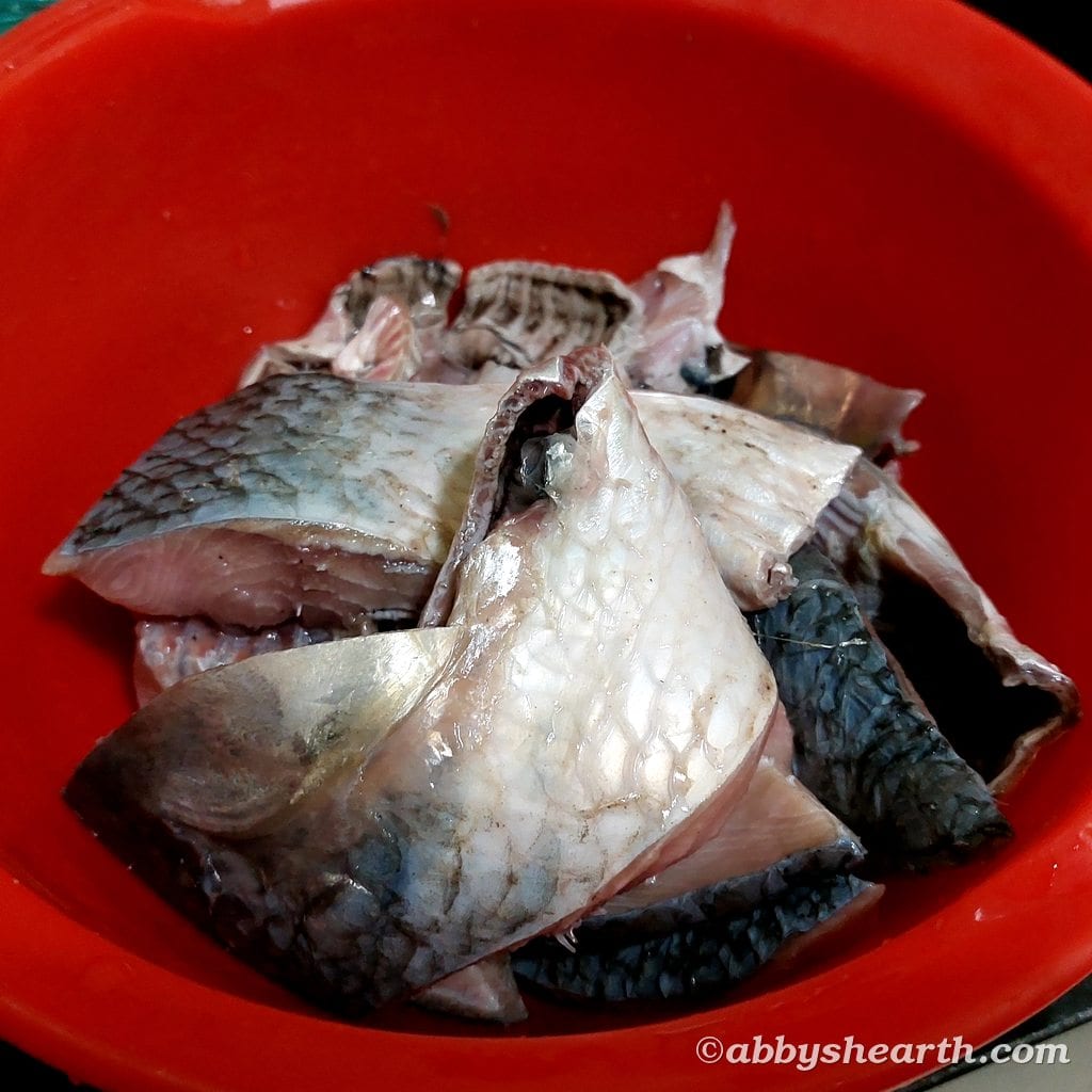 Pieces of palla fish in a red plastic dish.