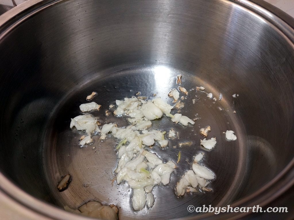 Crushed garlic frying in a pot.