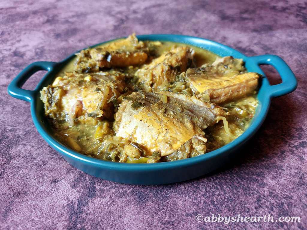 Golden eel curry called vaw khujit in a green dish.