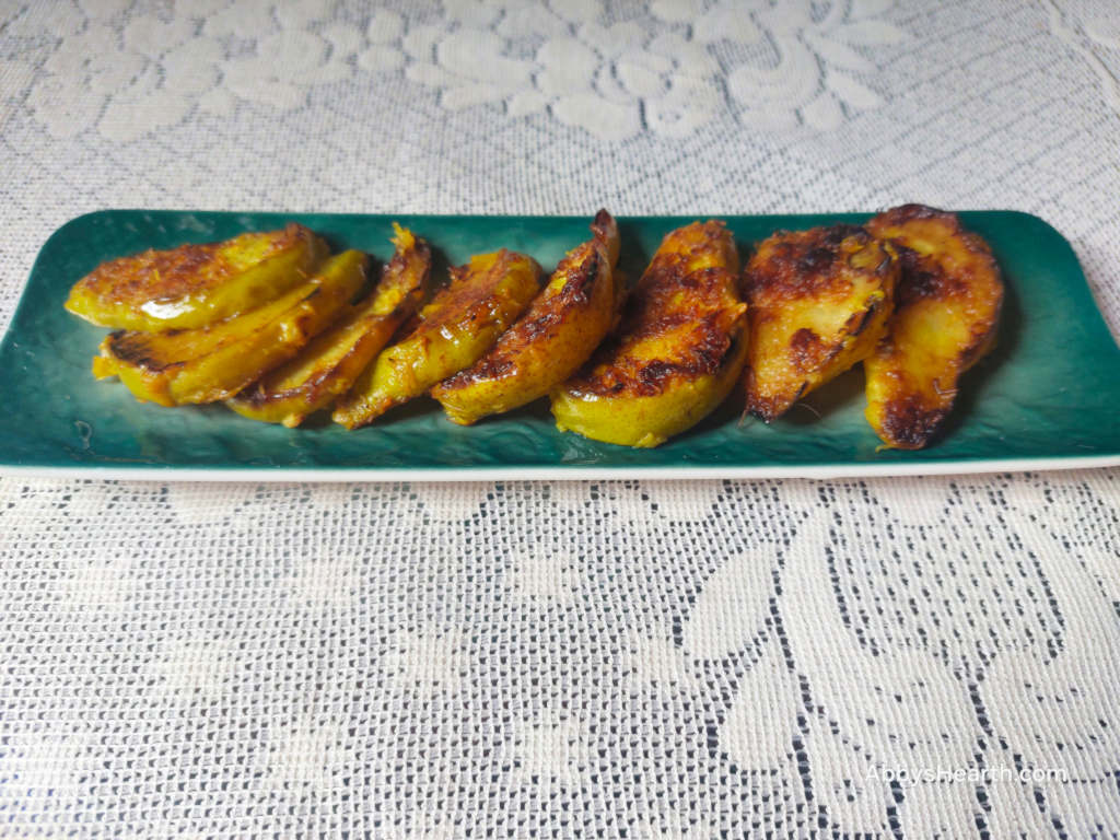 Slices of batter-fried pears in a green platter.