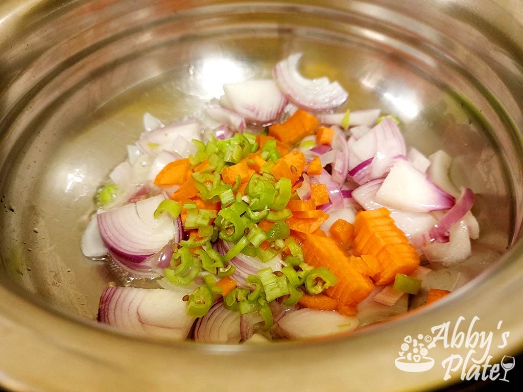 Diced carrots, chillies and onions in a pot.
