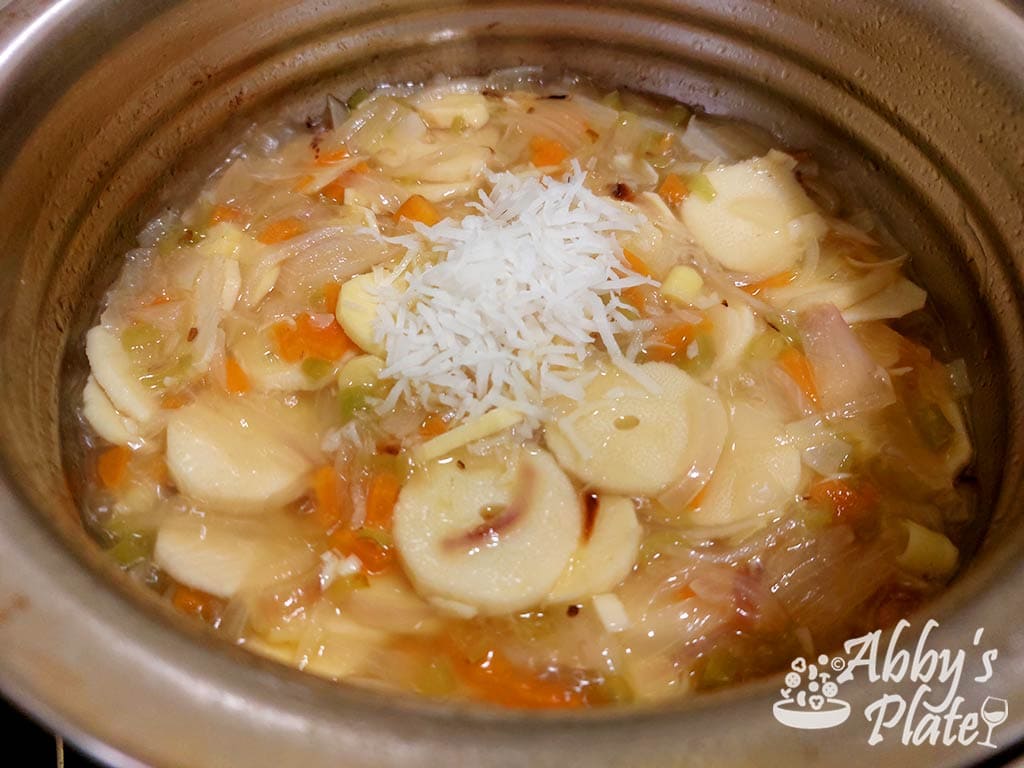 Coconut added to the bamboo shoot slices in the pot.
