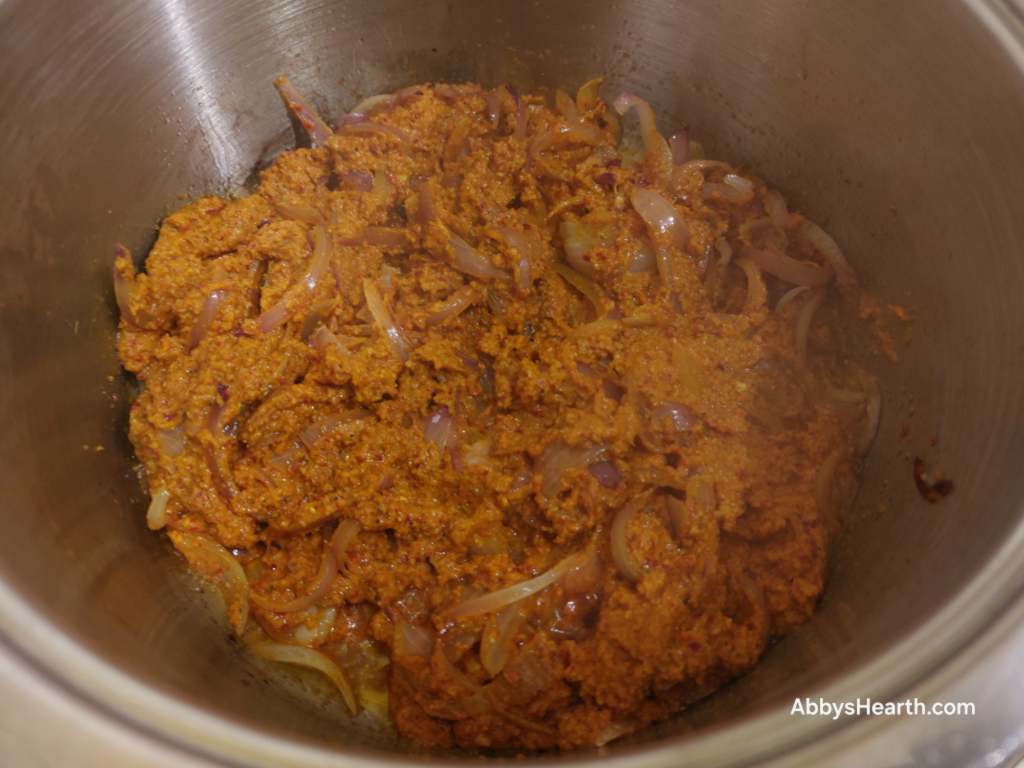 Add the ground masala to the onions and continue to cook.