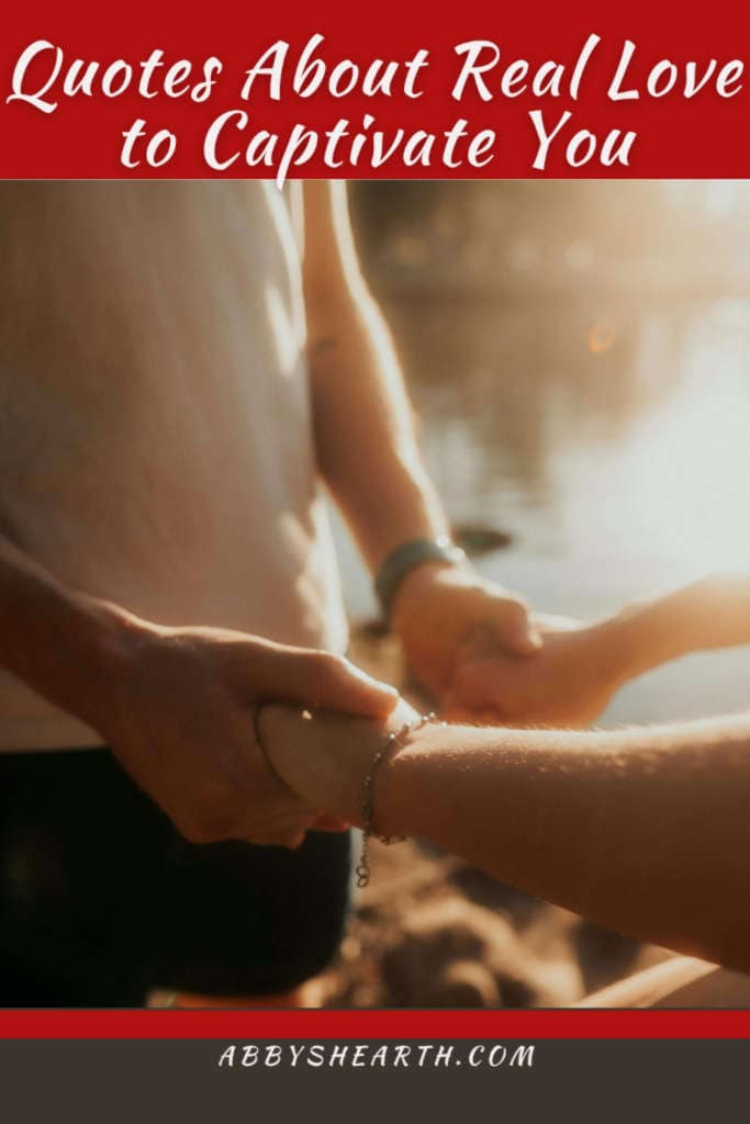 Man and woman holding hands near water shining off a lake.
