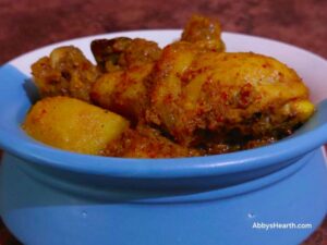 Reddish colored chicken frithad masala curry.