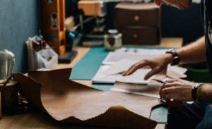 A man measuring leather.