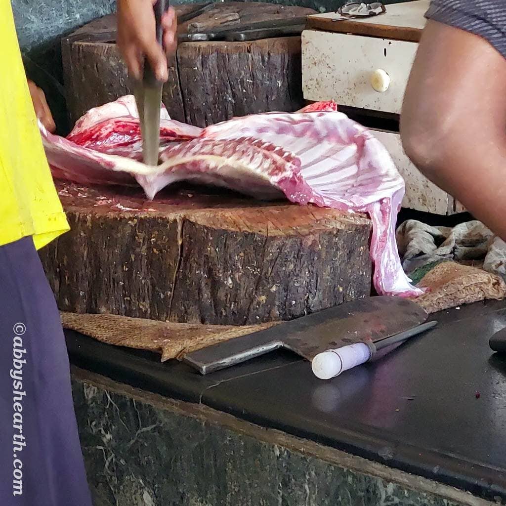 Butcher cutting the mutton ribs into chops.