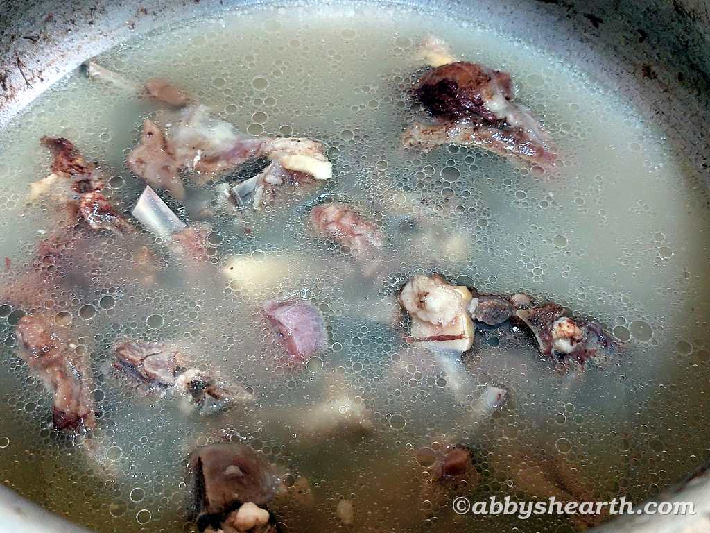 Mutton chops (ribs) in the water in a pressure cooker after cooking.