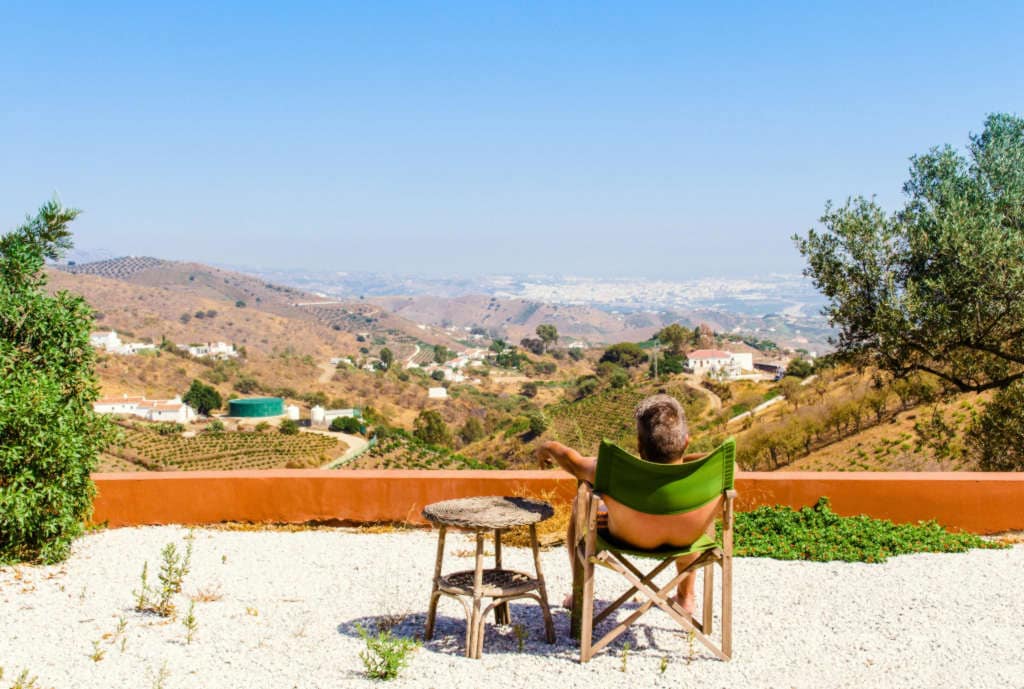 Man sitting on patio looking out over the horizon.