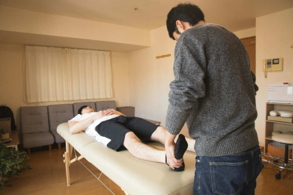 Man massaging a patients feet.