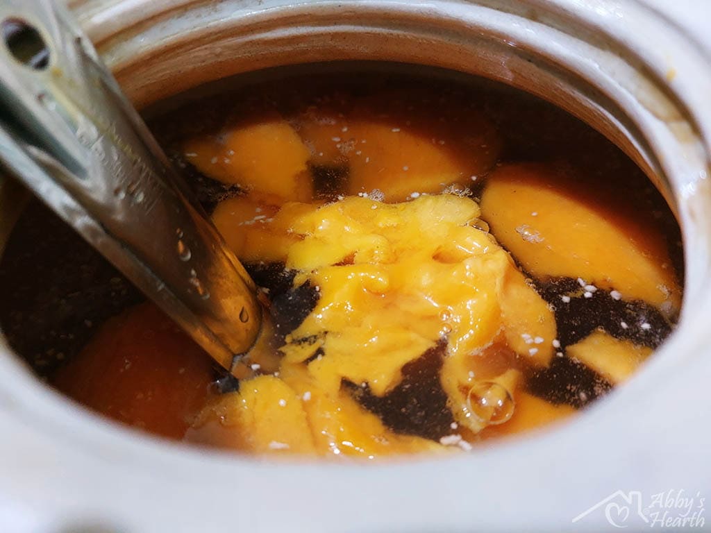Mixing with the ladle, mango floats to the top in the barni.