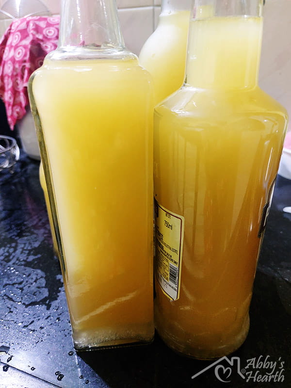3 bottles filled with mango wine.