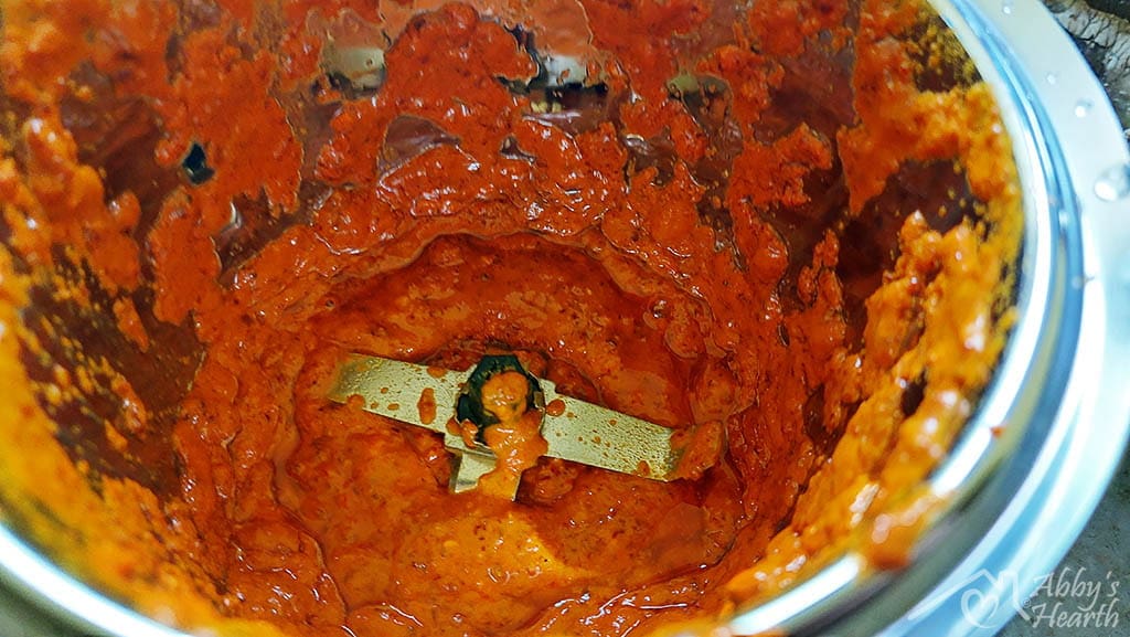 Red thick vindaloo masala paste in the grinder.
