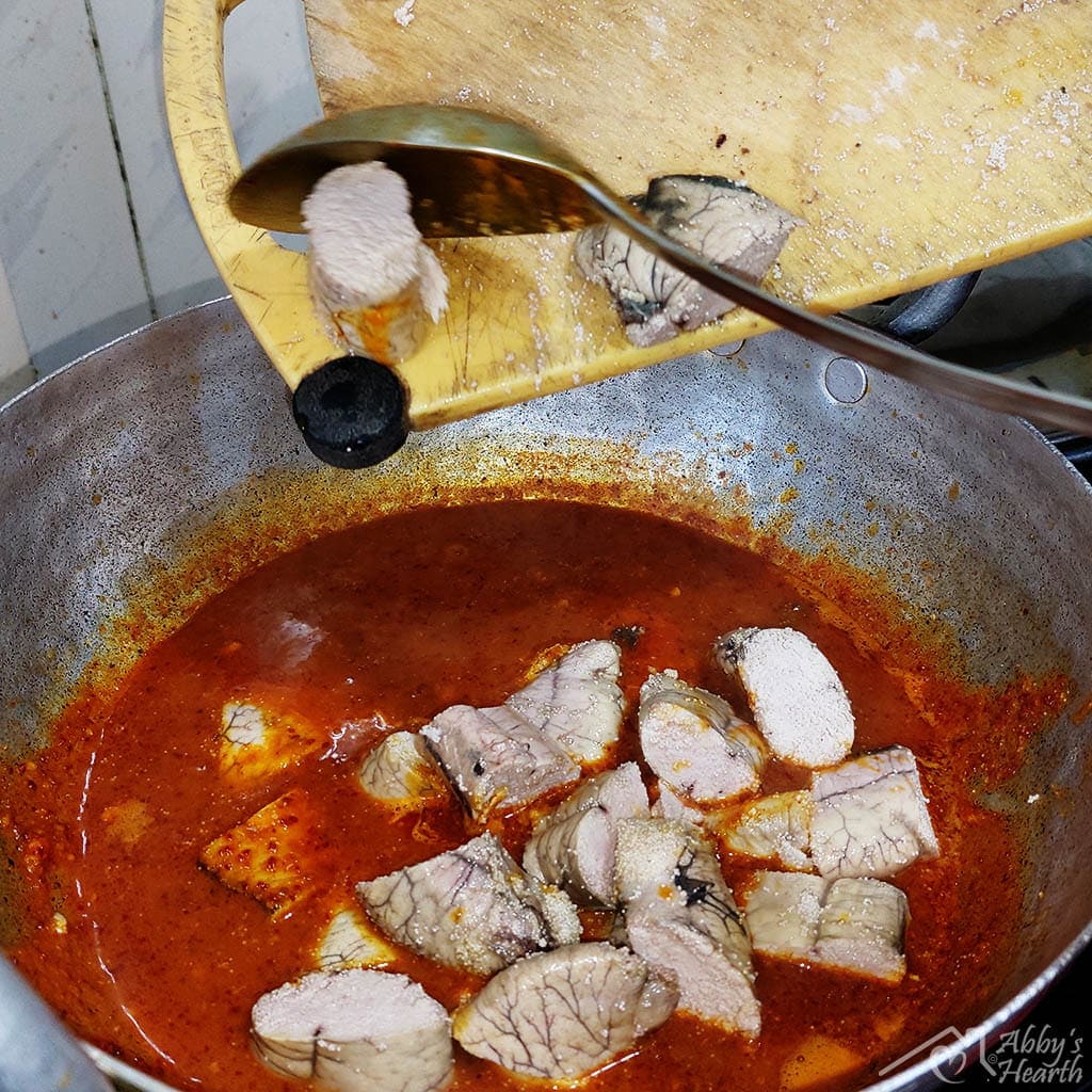 Add the hopped roe from the yellow cutting board to the masala in kadhai.