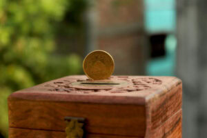 Coin in a wooden box depicting tithing.