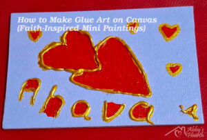 Glue art of Ahava love hearts in red and golden on lavender colour canvas.