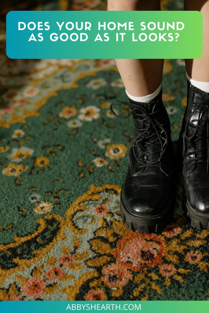 Legs with black boots on a green floral carpet.