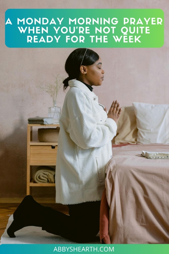 Lady kneeling near bed praying.