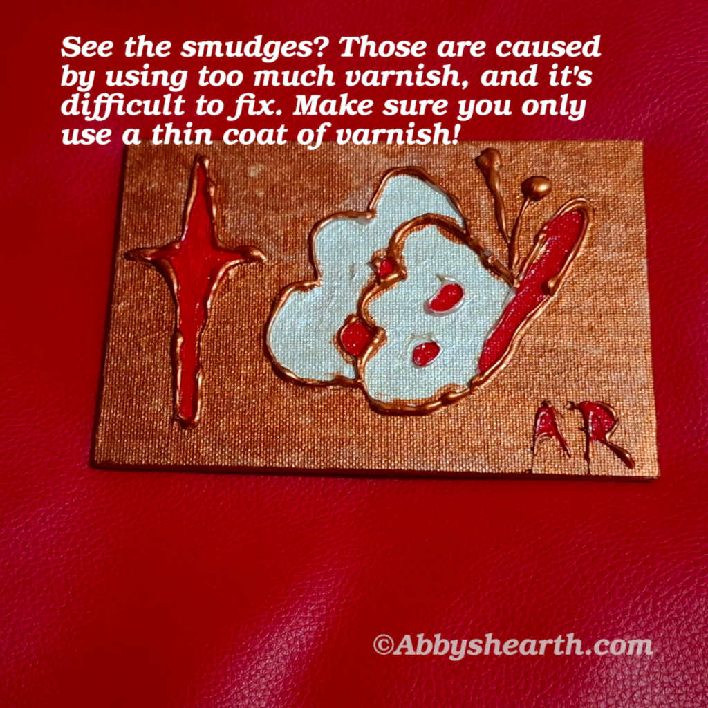 Glue art mini canvas showing white smudge marks from over-varnishing, an example of what to avoid when sealing handmade glue art.