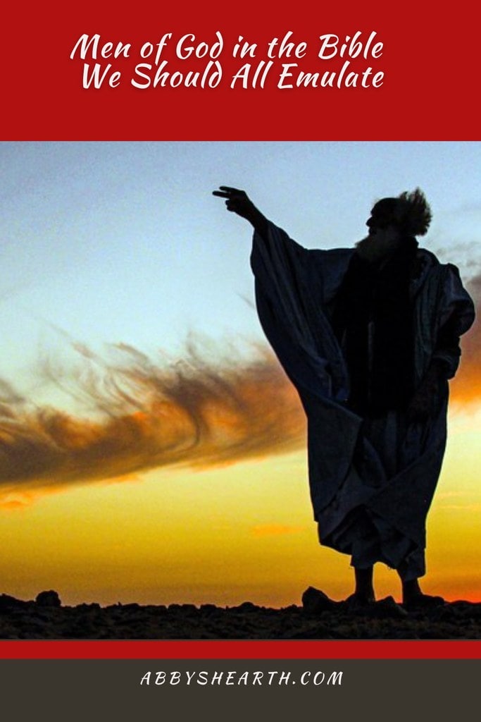 Man in desert clothes with hand raised.