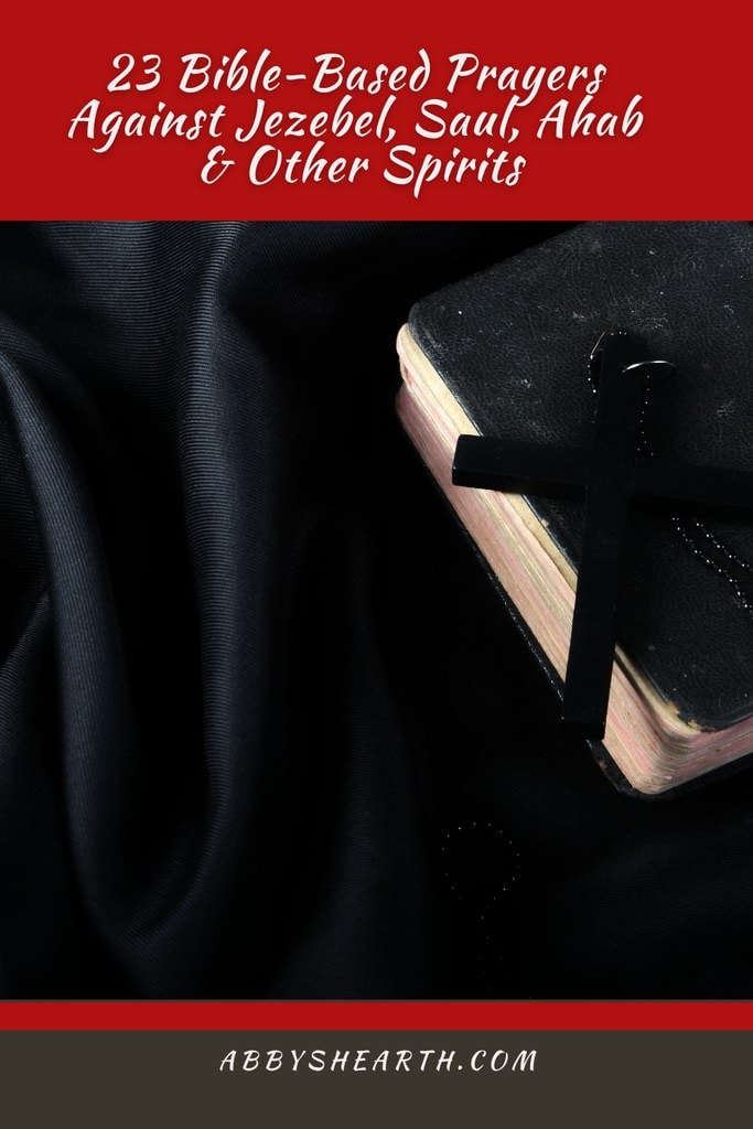 Bible and cross on a dark black cloth.