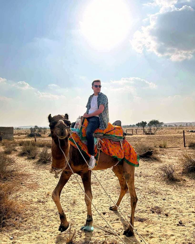 Man on a camel in the dessert.