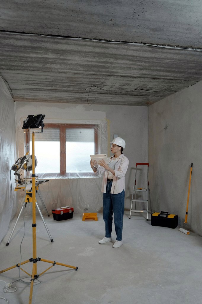 Lady looking at plan in a room being refurbished.