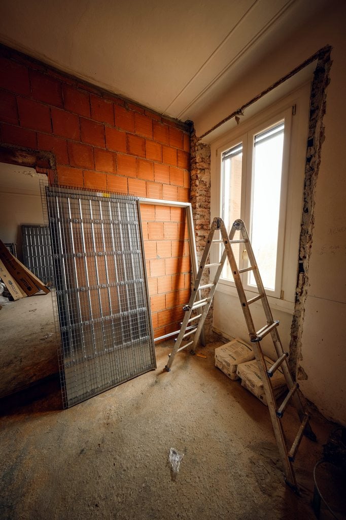 Ladder near a window in a house being refurbished.