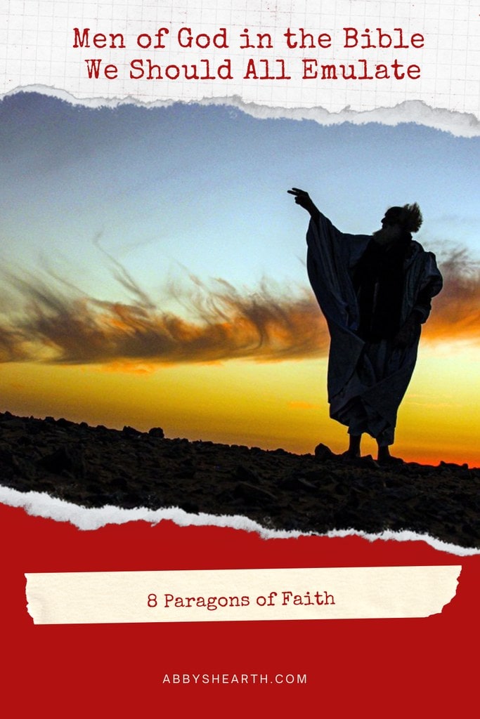 Man in Middle Eastern clothes in the desert with hand raised.