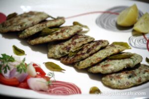 Brain cutlets in a plate with lemon wedges and salad.