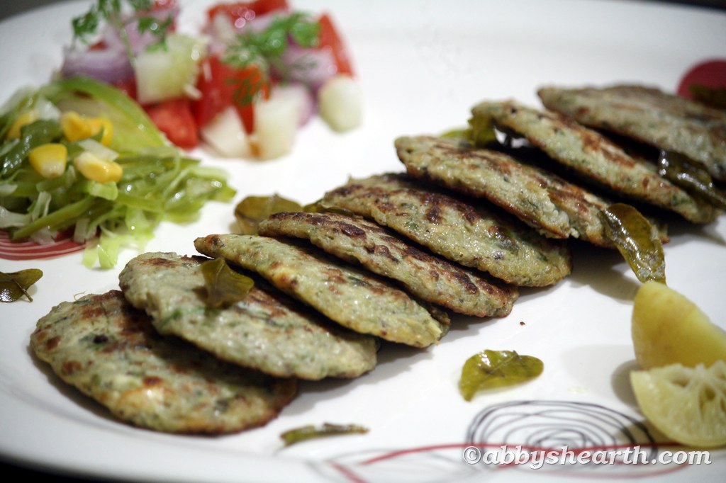 Brain cutlets in a plate with lemon wedges and salads.