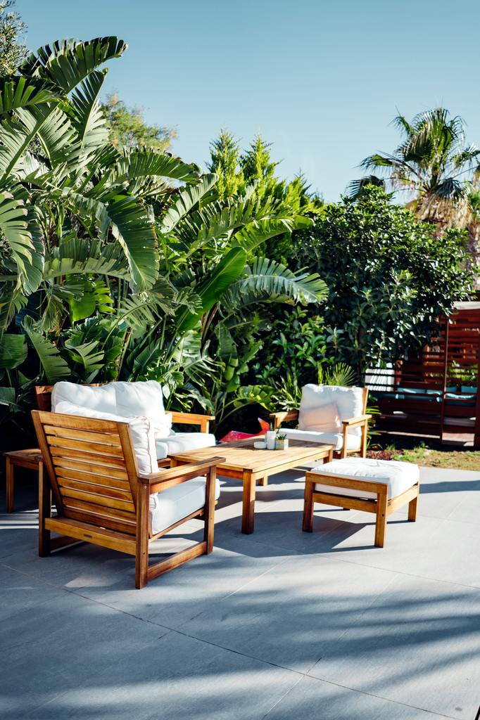 White chairs and table near coconut trees.