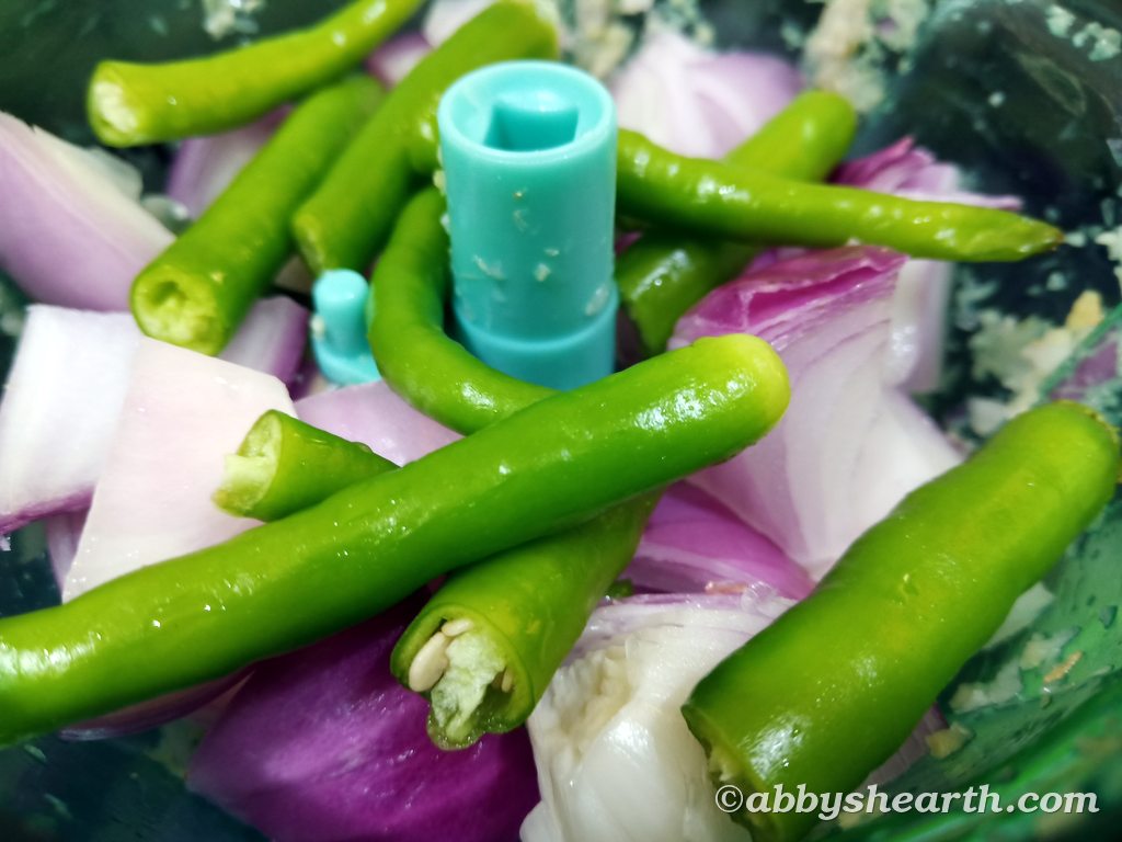 Chilies and onions in a mincer (like a mixer grinder).