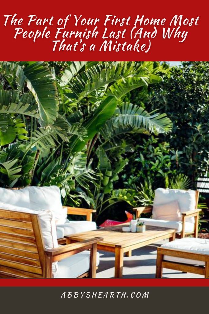 White chairs and table near palm trees and orange trees.