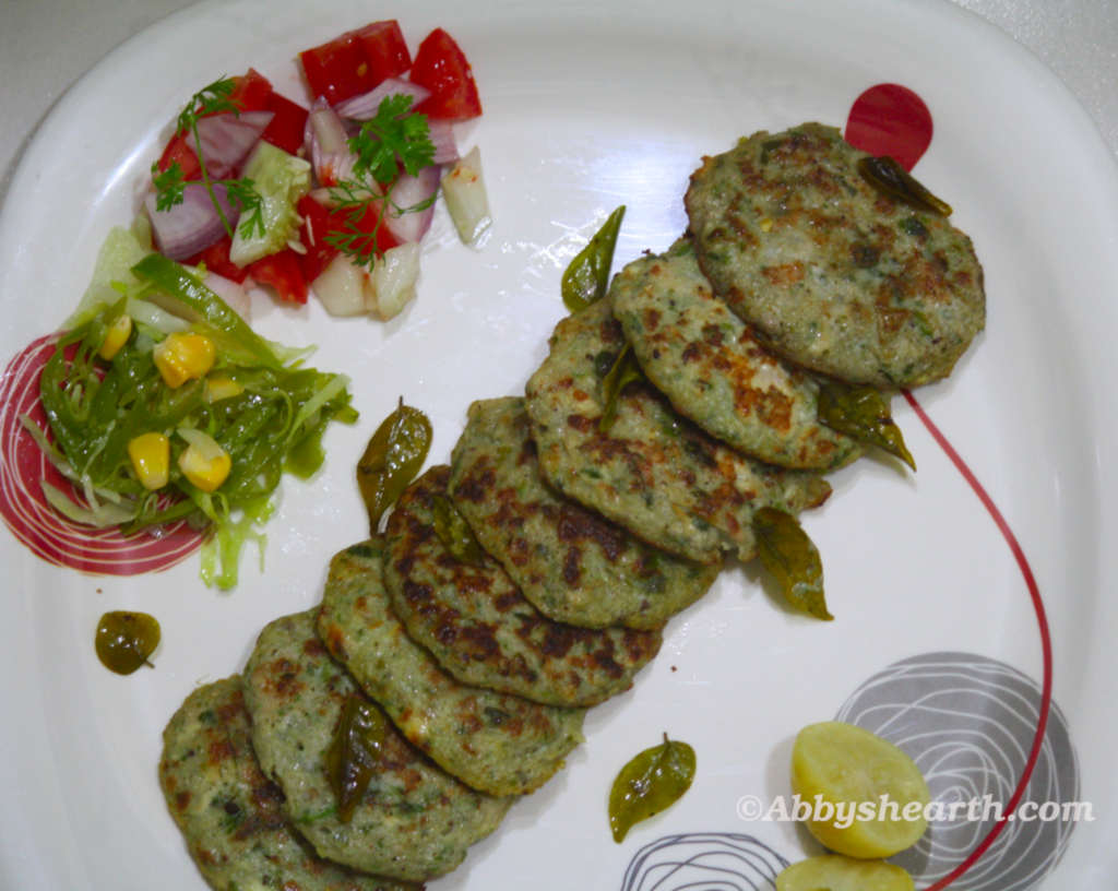 Top view of brain cutlets in a plate with lemon wedges and salads.