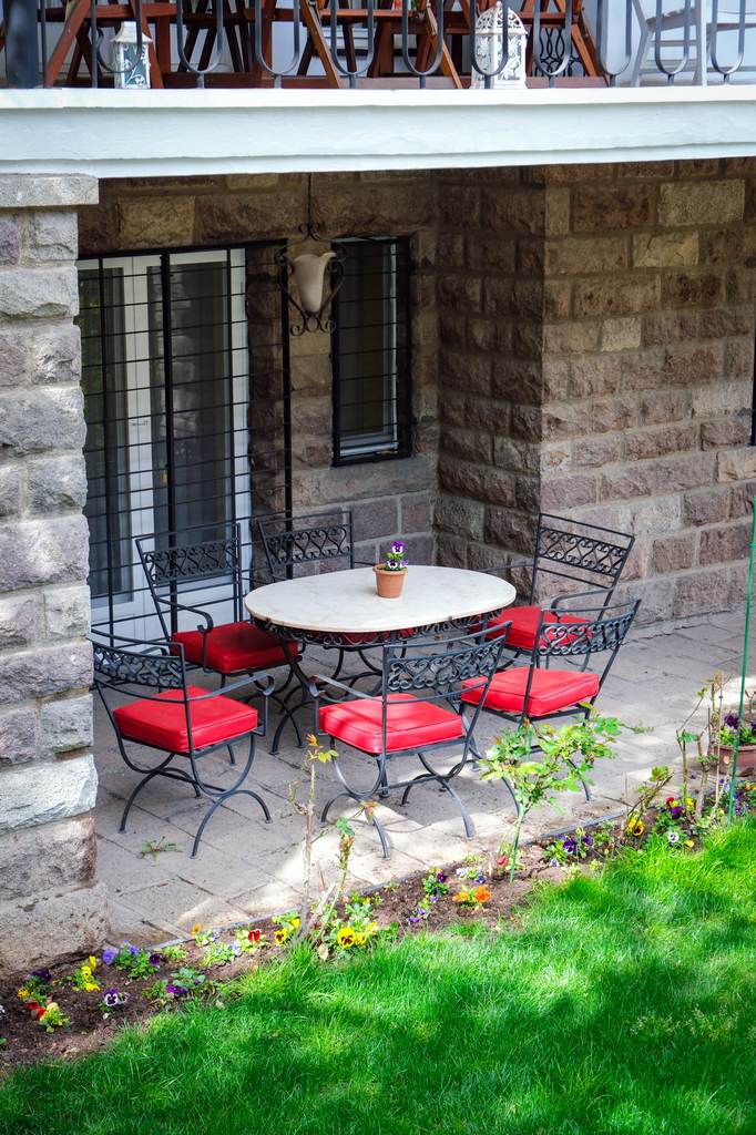 White table and red chairs outside backdoors.